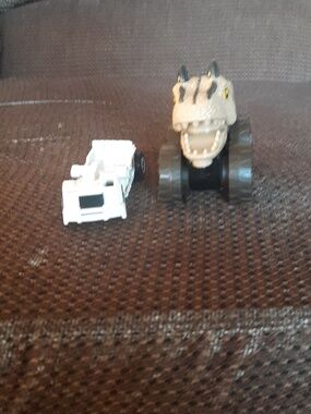 Small White Toy Vehicle with Black and Beige Figure